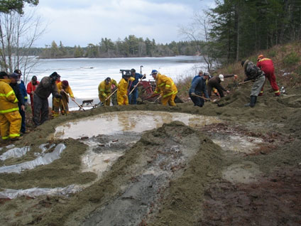 Firefighters work to prevent spills from entering storm drains, sewers, or waterways.