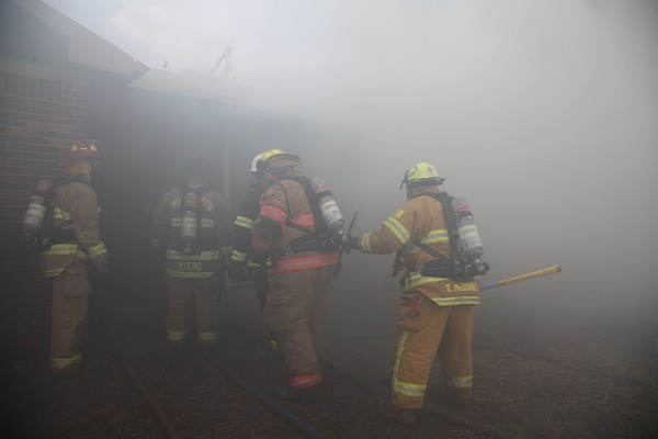 Firefighters moving through smoke