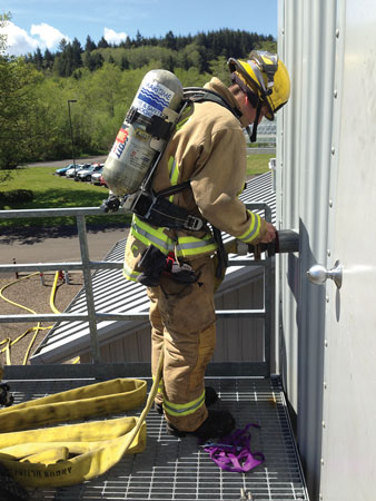  A firefighter connects a supply line to the vessel’s fire main using the international shore connection