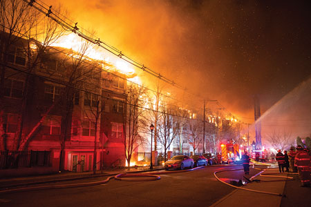 (1) Despite the fact that this complex was broken down into six buildings through the use of fire walls, the fire area still encompassed an entire city block along Undercliff Avenue. <i>(Photos 1-5 by Michael Coppola.) </i>“></td>
</tr>
<tr>
<td align=