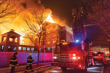 (5) Pedestal buildings such as this structure incorporate base-level “pedestals” on which the wood-frame dwelling units are built. The lit windows pictured are illuminating the parking level for residents, which was the only portion of the structure left standing after this massive fire. 