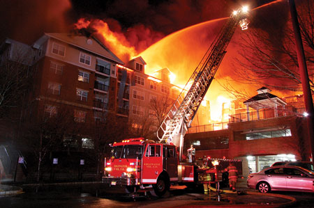 (9) A tower ladder applies water to Building C. Note the lack of access to the rear portion of the building. (Photo by Chris Tompkins.)