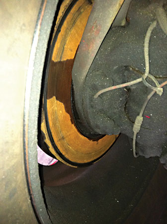 (9) Axle lubricant leaking from a seal runs down the surface of this brake rotor.