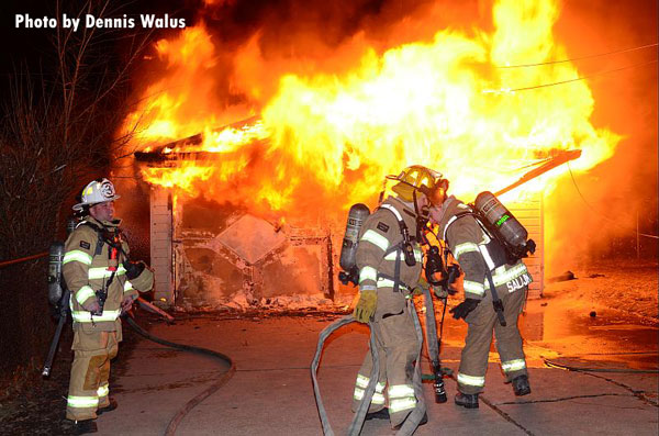 Firefighters stretch lines at a garage fire in Warren, Michigan.