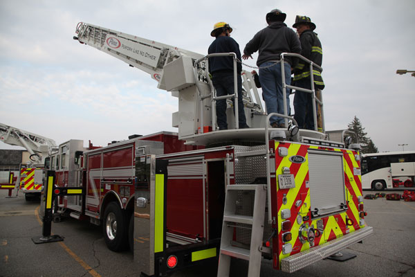 Firefighters on the back of an aerial device.