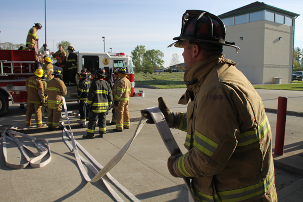 Firefighters examining hoseloads on the training ground.