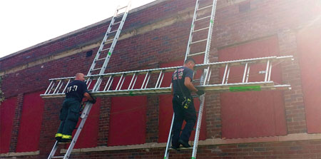 (3) Sliding a 35-foot portable ladder up two other ladders is strenuous and tiring work. In addition, it takes time, coordination, and communication to perform this tactic safely. (Photo by John Baker.)