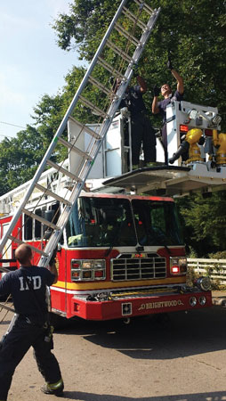 (4) With the bucket in the cradle position, firefighters can perform a beam raise with the portable ladder, which allows them to quickly position the ladder through both doors of the bucket. (Photo by John Baker.)