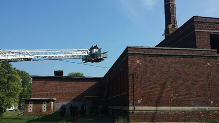 (9) When flying the tower ladder with the ladders extended outside the bucket, always use caution around overhead wires, tree branches, and other obstructions. (Photo by John Baker.)