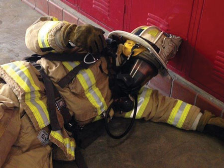 (1) This down firefighter lies down with the PASS device up to maximize the sound of the device and provide audible direction to search teams. (Photos by author.)