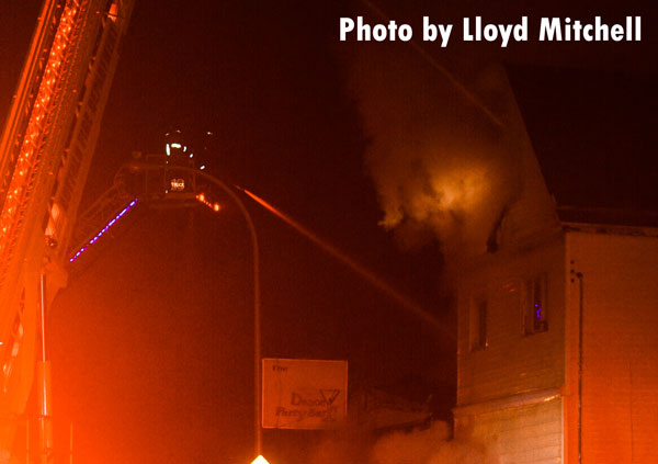 A Buffalo aerial device pours water on a structure fire.