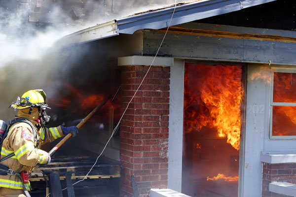 Firefighter performs horizontal ventilation during live-fire training.