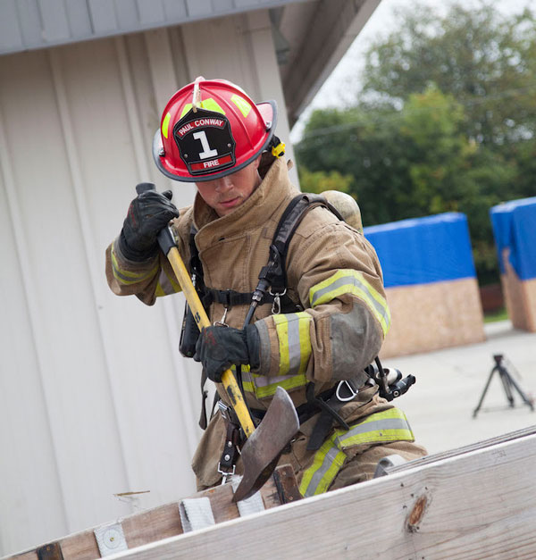 A firefighter wields an ax.