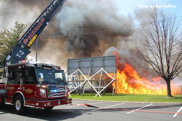 Fire apparatus parked in front of a raging brush fire in Secaucus, New Jersey.