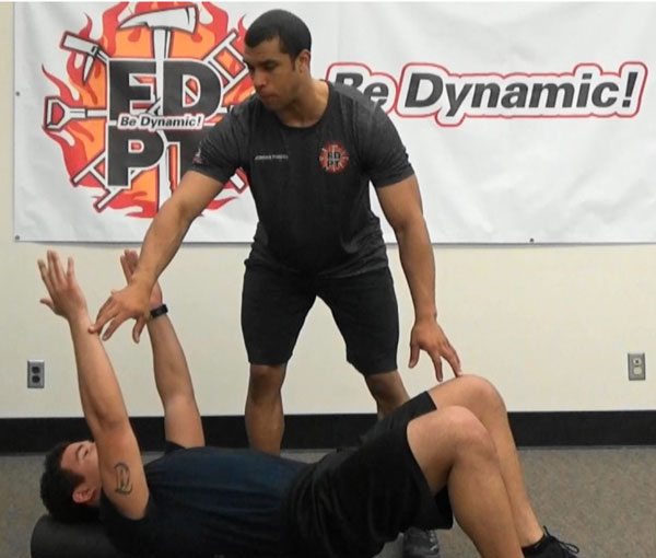 Jordan Ponder and a firefighter perform the Dead Bug exercise.