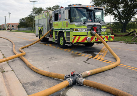 (3) An engine boosts pressure in a relay pumping operation by tapping into a four-way valve connected in a long supply hoseline.