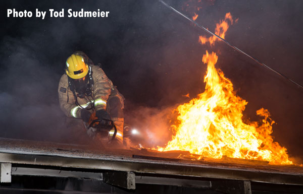 A firefighter works the roof of a structure fire in Redlands, California.