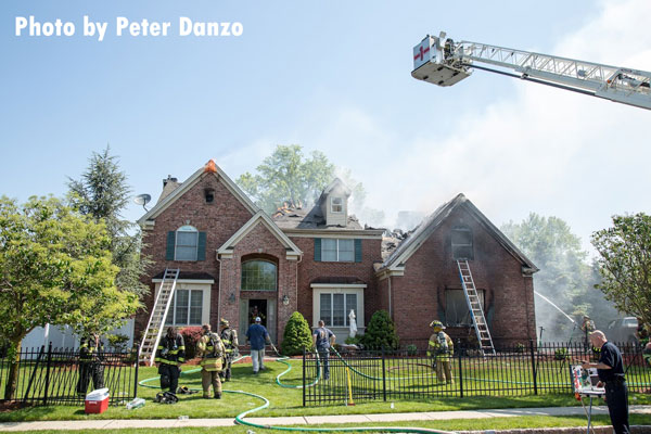 Fire crews work a fire in a large home in Fairfield, New Jersey.