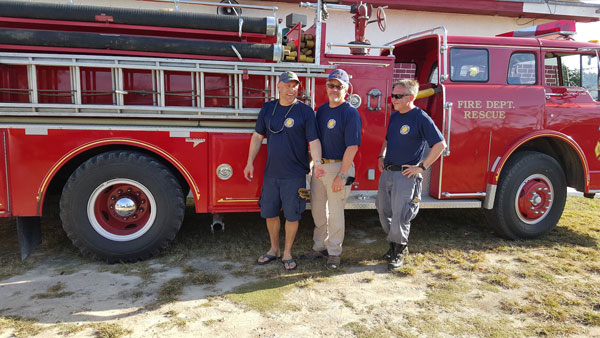 Firefighters in front of a fire apparatus.