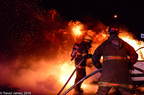 Firefighters operate a hoseline at a fire.