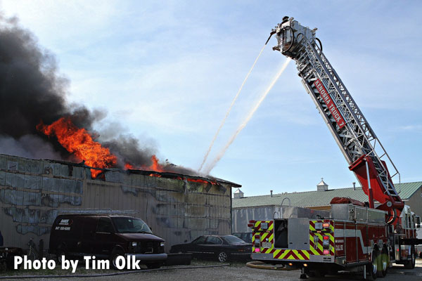 Firefighters using aerial master streams pour water on a structure fire in Salem, Wisconsin.