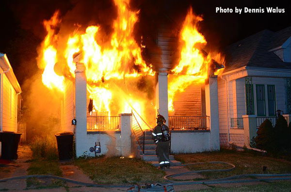 A firefighter confront massive flames shooting from a Detroit home.