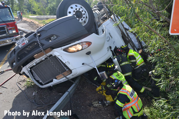 Firefighters work to stabilized the rolled vehicle.