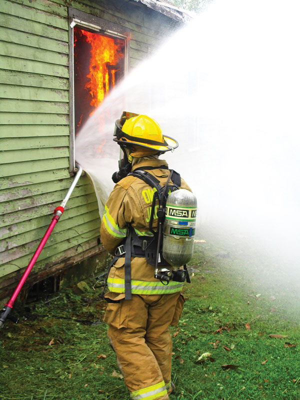 Firefighter using HydroVent at a structure fire.