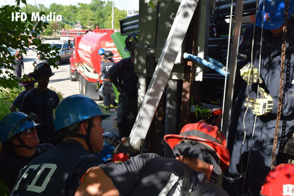 Indianapolis firefighters work to rescue a man trapped in a sewer pipe.