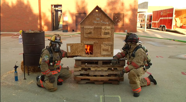 Firefighter manipulate the openings on a so-called dollhouse to simulate various fire behavior scenarios.