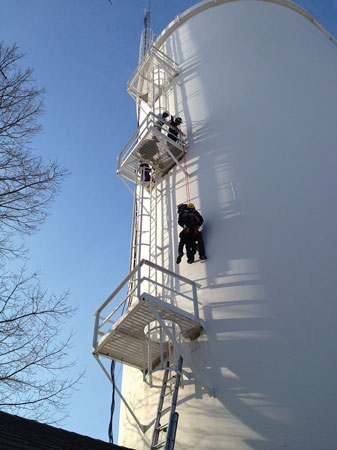 (2) Storage containers are target hazards for a rope rescue. Workers can fall onto their lifelines. In this photo, Murray, Kentucky, firefighters are practicing a pick-off.