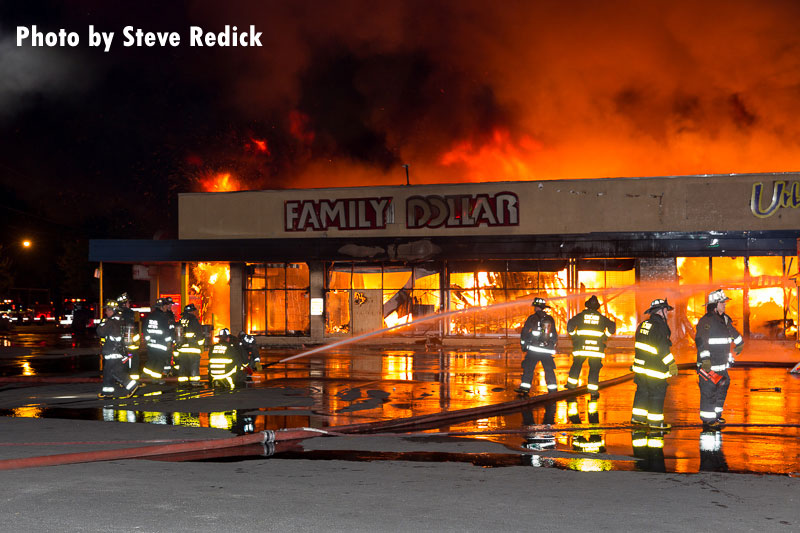 Firefighters operate a hoseline at the exterior of a commercial fire in Chicago, Illinois.