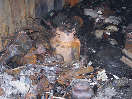 (3) This propane tank is another hazard found under densely packed contents. The source of the fire was undetermined. [Photo courtesy of the Spokane (WA) Fire Department.]