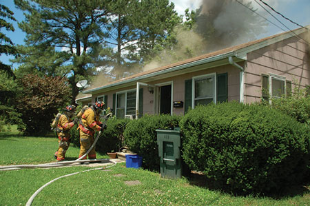 (5) The A side view of the same fire. The engine crew is about to make a “textbook-perfect” entry: full personal protective equipment, self-contained breathing apparatus, and hoseline charged and laid out in line with the doorway.