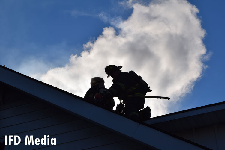 Firefighters work the roof during a recent Indianapolis house fire.