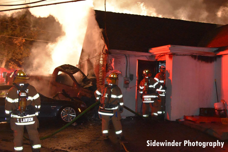 Firefighters advance a hoseline into a burning tavern in Colonie, New York.