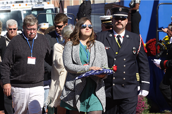 Family members receive a rose and American flag in honor of their fallen firefighter during a national memorial service at Emmitsburg, Md. on Sunday Oct. 9, 2016 (NFFF photo)