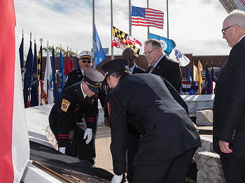 USFA Administrator Ernest Mitchell, NFFF Chairman Dennis Compton and FEMA Administrator Craig Fugate watch as plaques bearing the names of firefighters who died in the line of duty in 2015 and previous years are unveiled during a national memorial service in Emmitsburg, Md. on Sunday Oct. 9, 2016 (NFFF photo)