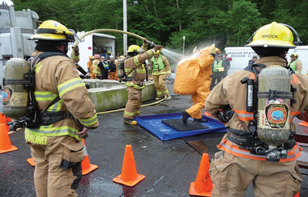 (1) Hazardous materials entry team members undergo decontamination after successfully shutting a leaking valve on an anhydrous ammonia delivery truck discharging vapors to the environment. Space in the exercise area was limited, so distances were compressed. (Photos by author.) 