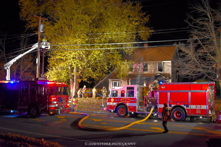 Firefighters and apparatus at the scene of a raging house fire in Brunswick, New York.