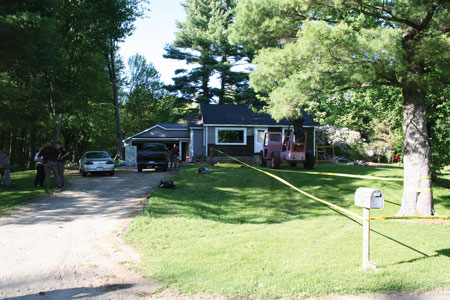 (1) The response scene postincident. The patient was to the left of the telescoping forklift, receiving CPR from his wife. The trees obscure the view of overhead wires. [Photos by the Ottawa County (MI) Sheriff’s Department.]