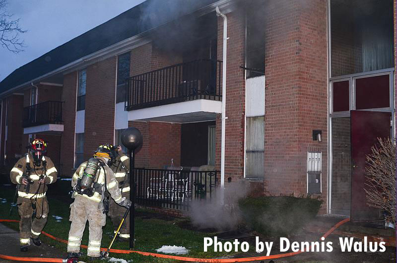 Firefighters at the scene of an apartment fire in Warren, Michigan, and smoke emerges from the balcony of one unit.