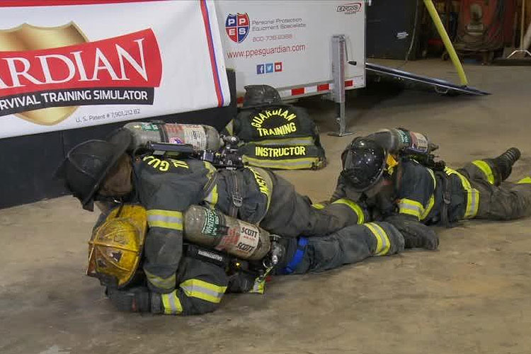 Firefighters perform a carry to remove a down firefighter.