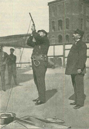 (2) Practising with life-line gun; McAdam at right. 