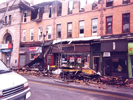 (3) The parapet and cornice of these structural carcasses collapsed without warning, peeling away all at once. A fire line and fire watch had been set up and no one was in the collapse zone when it occurred.