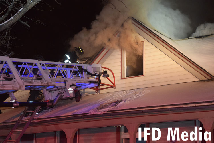 Indianapolis firefighter on an aerial ladder at the scene of a working apartment fire.