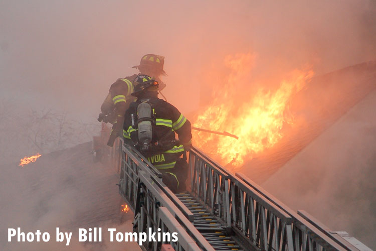 Firefighters perform vertical ventilation at the scene of a fatal house fire in Little Ferry, New Jersey.