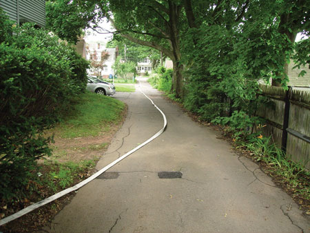 <b>(19) </b>The nozzle firefighter advances the line toward the structure, laying it out as he goes. <i>(Photos 17-19 by Joe Scaglione.)</i>