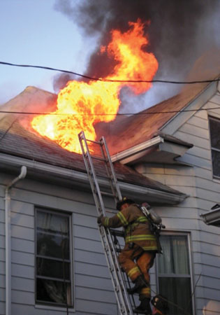 (1) Fire jets out of a vent hole after the ladder driver cuts and opens the roof to ventilate the attic. (Photos by author.)