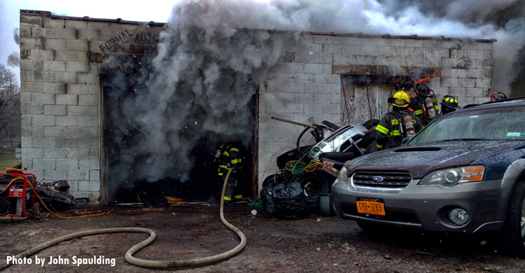 Firefighters advance a hoseline inside a concrete structure during a Rochester fire.